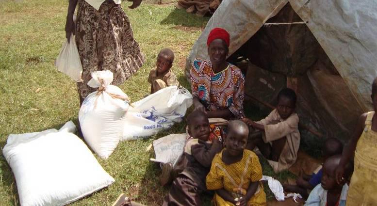 Close-up of families and children near a tent with supplies